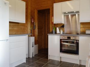 a kitchen with white cabinets and a stove at Cider Mill Lodge - Hw7420 in Tintern
