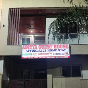 贾巴尔普尔Aditya guest house的房屋前方的标志