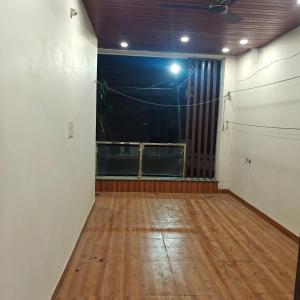 贾巴尔普尔Aditya guest house的一间空房间,铺有木地板,设有窗户 更多14张照片