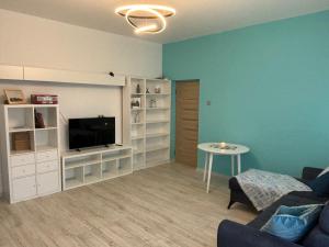 a living room with a couch and a tv and a table at Vecpilsētas apartaments in Cēsis