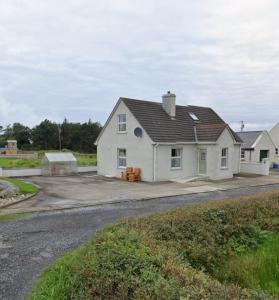 uma casa branca sentada ao lado de uma estrada em Sonnys Rest em Ardara