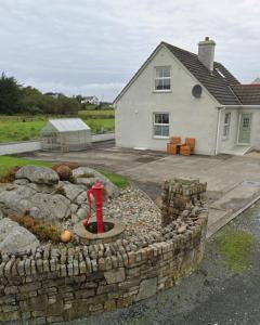 um hidrante em uma parede de pedra em frente a uma casa em Sonnys Rest em Ardara