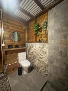 a bathroom with a toilet in a room at Lodges atypiques, filet suspendu ou lit mobile pour expérience unique sous les etoiles in Petit-Bourg