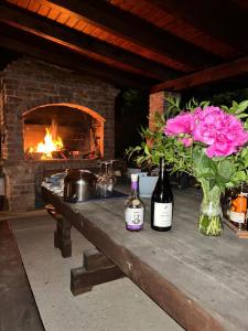 two bottles of wine and flowers on a table with a fireplace at Podroom LauMarYvo in Dugo Selo +63 photos