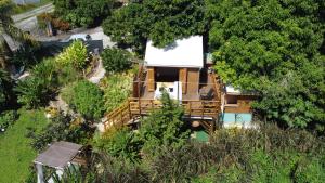 プティ・ブールにあるLodges atypiques, filet suspendu ou lit mobile pour expérience unique sous les etoilesの木々に囲まれた家屋の頭上