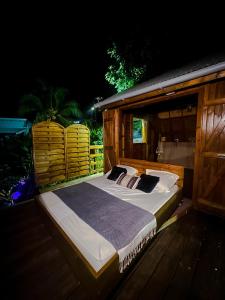 a large bed sitting on a deck at night at Lodges atypiques, filet suspendu ou lit mobile pour expérience unique sous les etoiles in Petit-Bourg