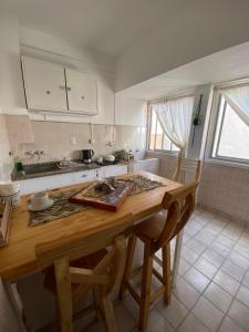 a kitchen with a wooden table with two chairs at VISTA AL MAR HOSPEDAJE Solo mujeres in Mar del Plata