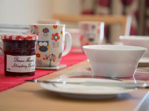een tafel met een pot jam en een kopje koffie bij Apartment 5 Latitude 51 Westward Ho! in Westward Ho