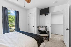 a bedroom with a bed and a tv and a chair at The Tree House on Lake Brownwood in Brownwood