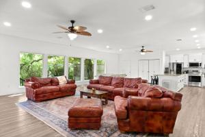 a living room with two leather couches and a table at The Tree House on Lake Brownwood in Brownwood