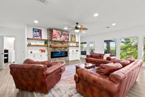 a living room with two leather couches and a fireplace at The Tree House on Lake Brownwood in Brownwood