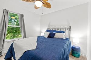 a bedroom with a blue bed and a window at The Tree House on Lake Brownwood in Brownwood