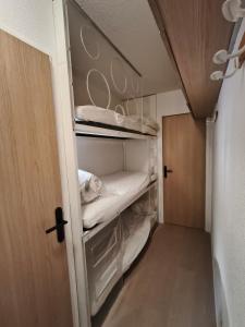 a small closet with a bed in a room at Appartement a la Foux d'Allos in Allos +3 photos