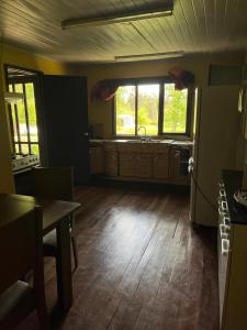 cocina con nevera y suelo de madera en Casa en Panguipulli, en El Cerrillo 4 fotos más