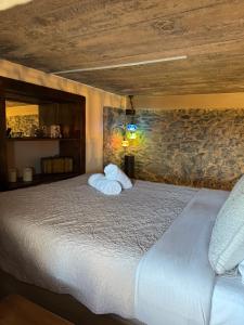 a bedroom with a bed and a stone wall at Victoria Tiny Stone House in Ponta do Pargo +35 photos
