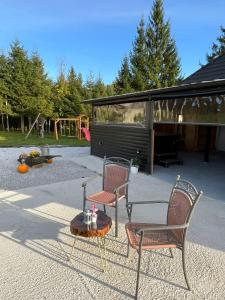 twee stoelen en een tafel voor een speeltuin bij Vučja Aura Gorski Kotar in Vrbovsko