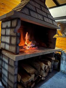een bakstenen oven met een vuur erin bij Vučja Aura Gorski Kotar in Vrbovsko
