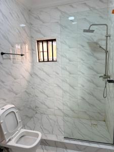 MamaMsquare Comfort Hotel的浴室配有马桶和玻璃淋浴房