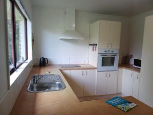 a kitchen with a sink and a stove at House in Restful Setting in Whangarei