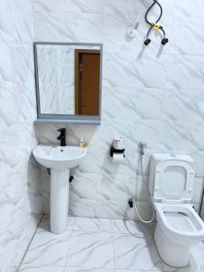 MamaMsquare Comfort Hotel的浴室里有洗手池、马桶和镜子。