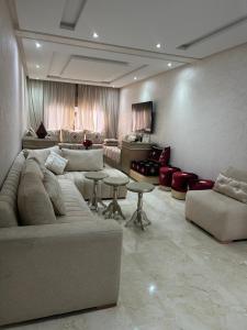 a living room with a couch and a table and chairs at Rabat Explorer Apartment in Rabat