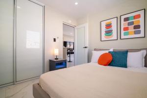 - une chambre avec un lit doté d'un oreiller orange dans l'établissement SunJoy Gateway Lux 2 bedroom House by PH, à Carolina