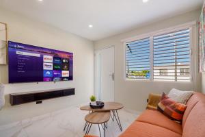 - un salon avec une grande télévision et un canapé dans l'établissement SunJoy Gateway Lux 2 bedroom House by PH, à Carolina
