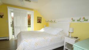 1 dormitorio con cama blanca y paredes amarillas en Dunescape, en West Cape May