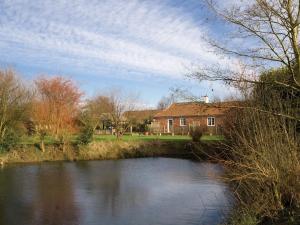 a house next to a river with a building at Mallard Cottage - E3751 in Leverton