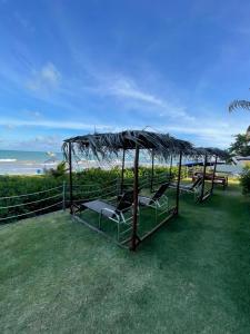 een groep stoelen onder een parasol op het gras bij Pousada Grandmar, Maragogi in Maragogi