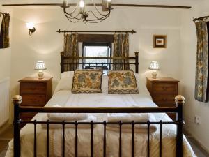 a bedroom with a large bed with two night stands at Mushroom Cottage in Castleton