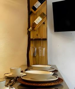 une table avec des assiettes et des tasses blanches dessus dans l'établissement Flat Ruanda para casal em meio à natureza!, à Nova Friburgo