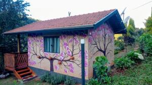 a small house with flowers painted on it at Sonho na Serra Chalé 1 in Gonçalves