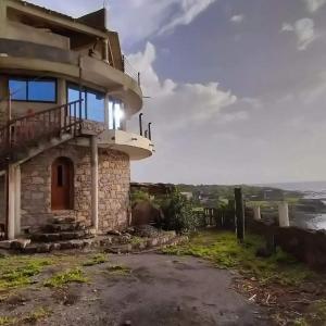 una casa en una colina con el océano en el fondo en Casa Fabrice, en Ribeira da Prata