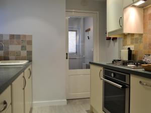 eine Küche mit Spüle und Herd oberen Backofen in der Unterkunft Lower Sycamore Cottage in Ambleside