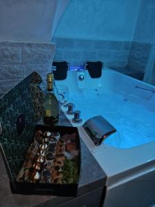 una vasca da bagno con una bottiglia di vino e una scatola di sushi di Volcano Home a Catania