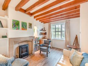 a living room with a fireplace and wooden ceilings at Ty Newydd Y Graig - 28017 in Tremeirchion