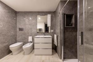 un bagno con wc, lavandino e doccia di Volcano Home a Catania Altre 11 foto