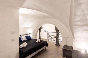 una camera con letto in una stanza con arco di Volcano Home a Catania