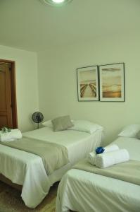 three beds in a room with white walls at live Medellín desde un Apartamento Céntrico y Cómodo in Medellín