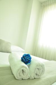 a blue rose on a pile of towels on a bed at live Medellín desde un Apartamento Céntrico y Cómodo in Medellín