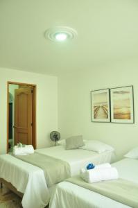 a room with four beds with white walls at live Medellín desde un Apartamento Céntrico y Cómodo in Medellín