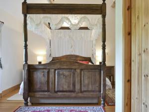 an old wooden bed with a canopy in a room at Swallows Loft in Cromford