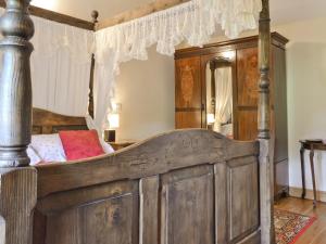 a bedroom with a wooden bed with a canopy at Swallows Loft in Cromford