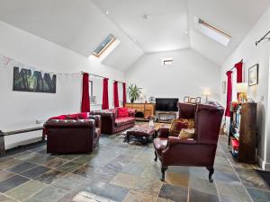 a living room with leather chairs and a couch at Kite Cottage in Capel-Ifan