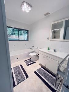 a bathroom with a toilet and a sink and a tub at Holiday Home In Red Hill Papakura Auckland in Buckland +23 photos