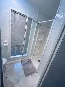 a bathroom with a shower and a toilet at Holiday Home In Red Hill Papakura Auckland in Buckland