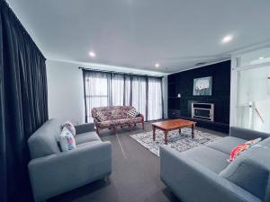 a living room with two couches and a coffee table at Holiday Home In Red Hill Papakura Auckland in Buckland