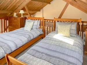 two beds in a room with wooden ceilings at Heron in Welney