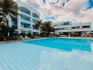 a large swimming pool in front of a building at Ponta Negra Beach Praiano Flat in Natal